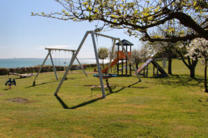 Der Spielplatz und die Fußballwiese neben dem Ein- und Ausgang und der Treppe zum Strand an der Steilküste