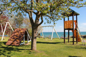 Der Spielplatz neben der Fußballwiese mit Blick auf die Ostsee entlang der Steilküste