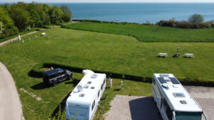 Die Panorama-Zeltwiese uund durch Seilzaun abgegrenze Hundewiese mit Sitzgelegenheit und direktem Blick auf die Ostsee Außerdem Zubringer vom Platz auf öffentlichen Fußweg in Richtung Pelzerhaken und Neustadt